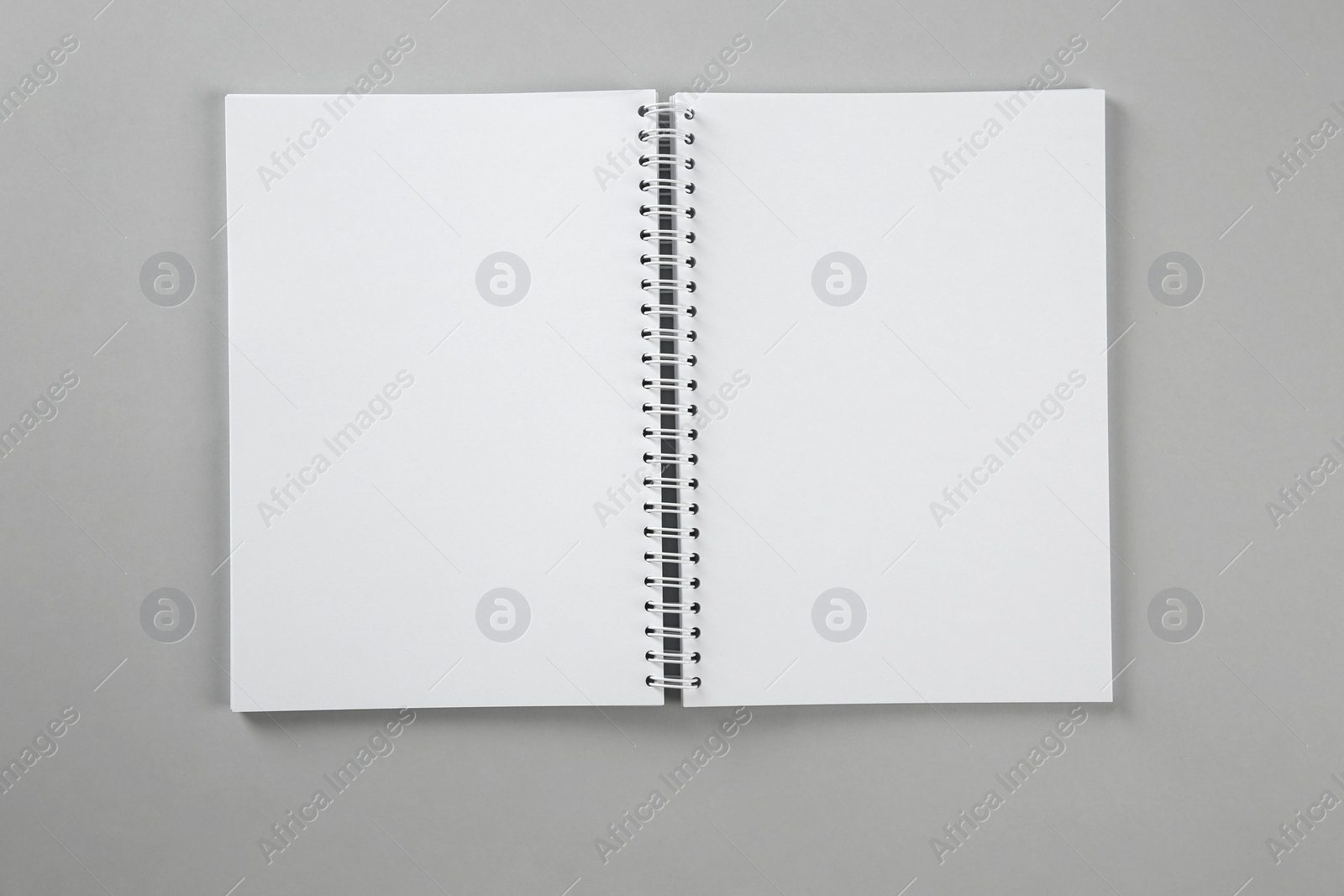 Photo of Open blank notebook on grey background, top view. Mockup for design