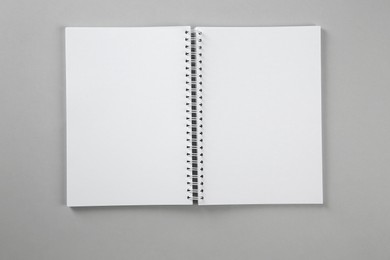 Photo of Open blank notebook on grey background, top view. Mockup for design