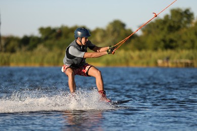 Photo of Teenage boy wakeboarding on river. Extreme water sport