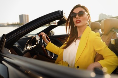 Photo of Beautiful businesswoman in luxury convertible car outdoors