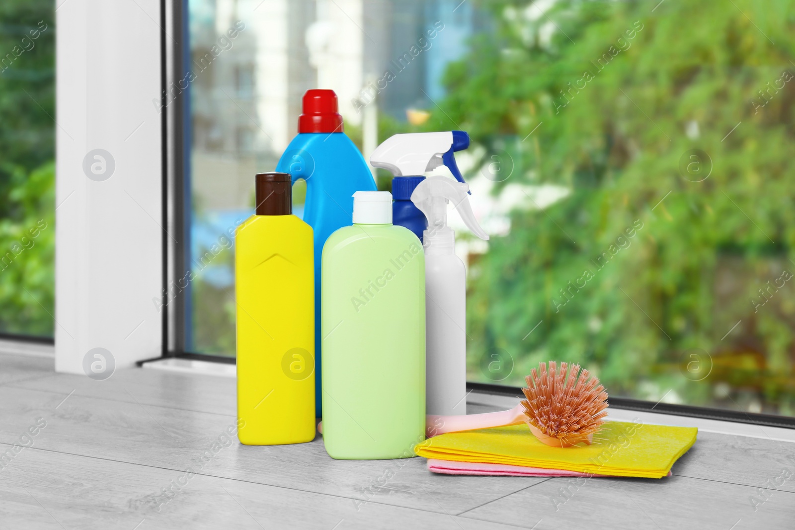 Photo of Different cleaning supplies, brush and rags on window sill indoors