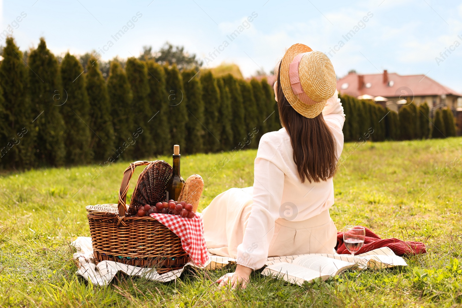 Photo of Woman having picnic in park, back view