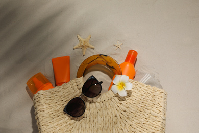 Flat lay composition with sun protection products on sand