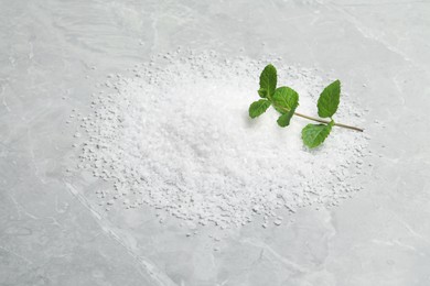 Photo of Natural sea salt on light grey marble table, top view
