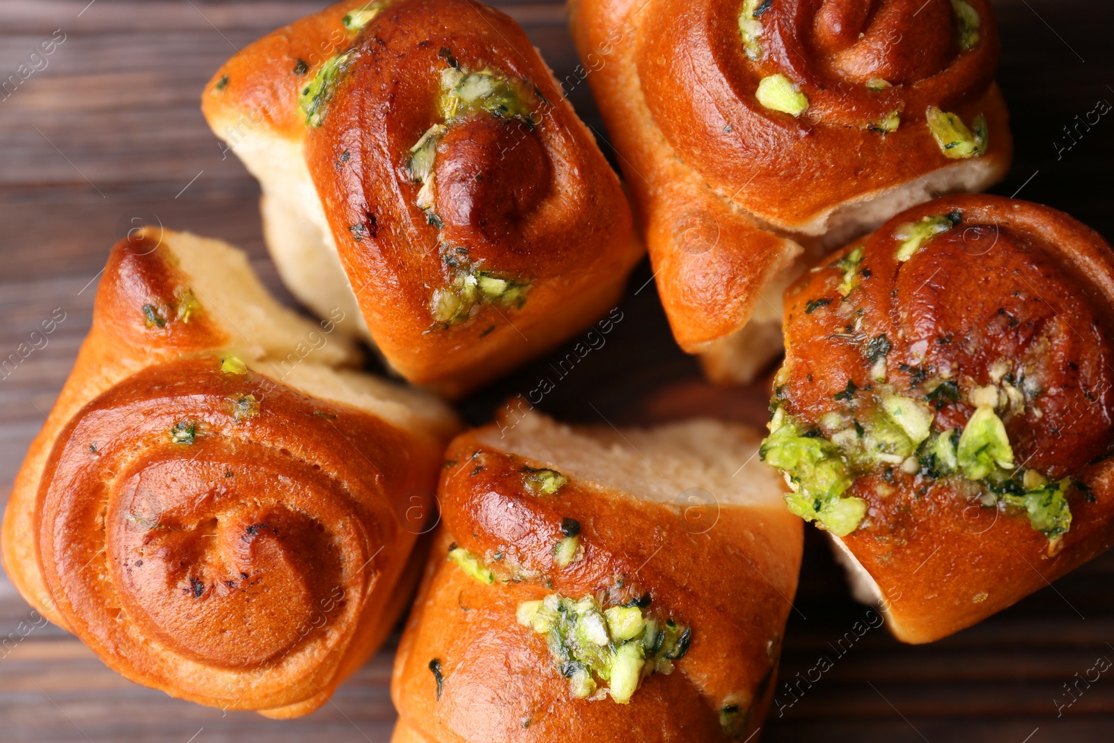 Photo of Tasty fresh pampushky. Traditional Ukrainian buns with garlic on wooden table, flat lay