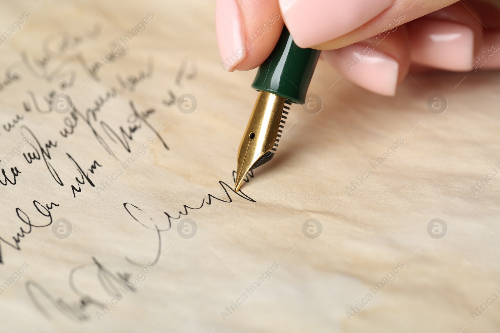 Photo of Woman writing letter with fountain pen, closeup