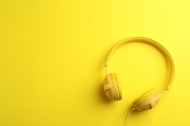 Stylish headphones on color background, top view. Space for text