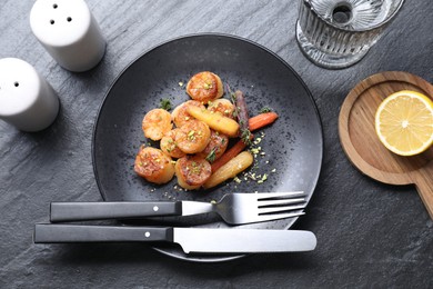 Photo of Delicious fried scallops served on dark gray textured table, flat lay