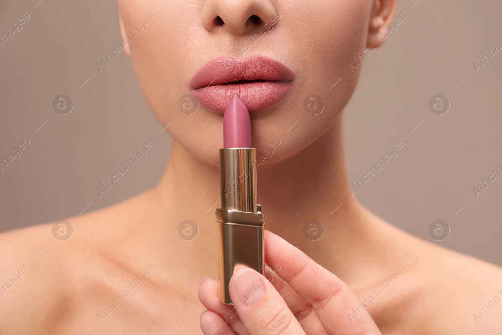 Photo of Woman with pink lipstick on brown background, closeup