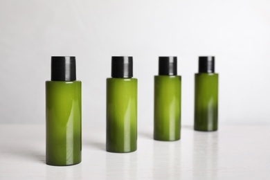 Photo of Mini bottles with cosmetic products on light table