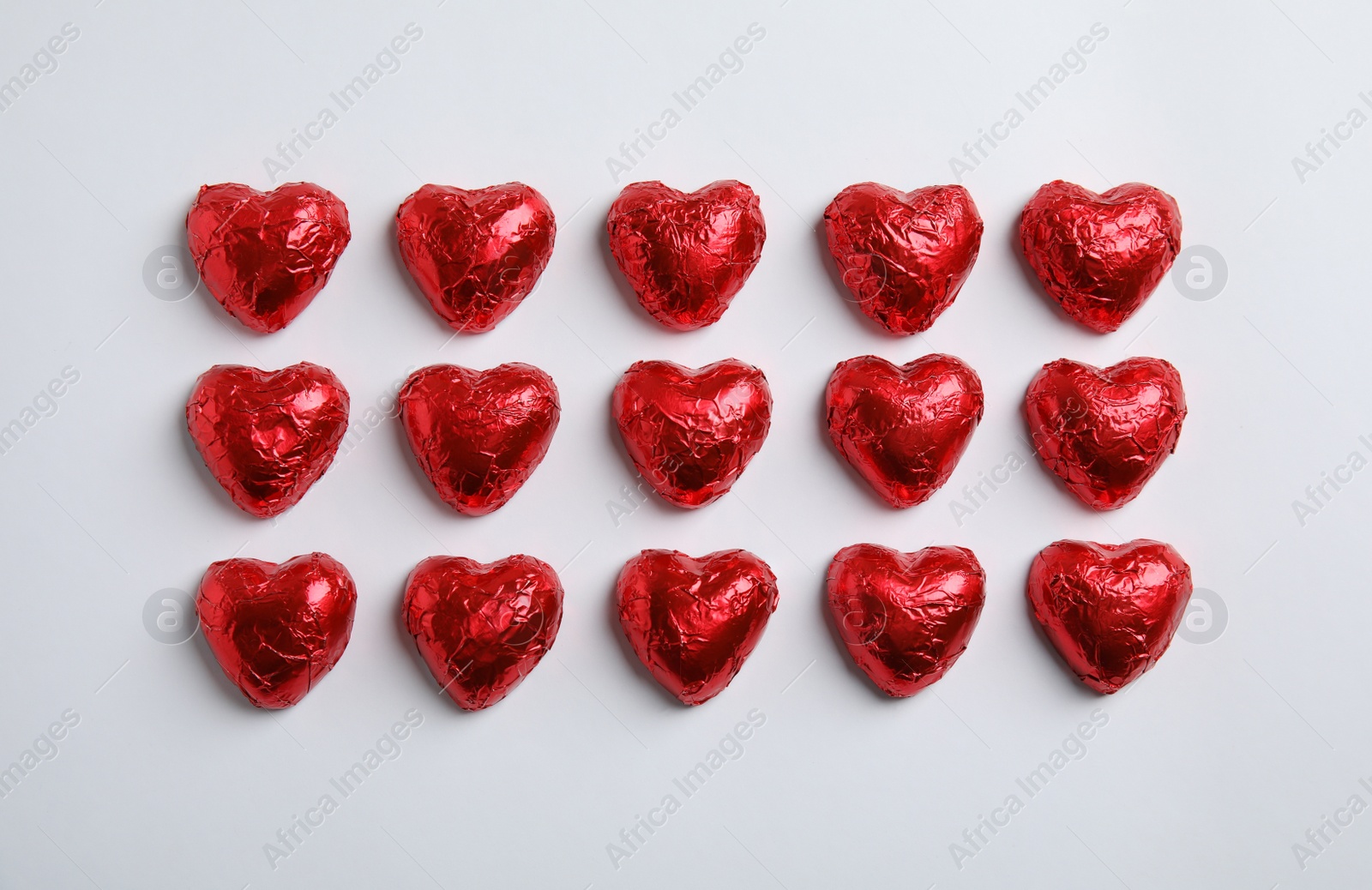 Photo of Heart shaped chocolate candies on white background, flat lay. Valentine's day treat
