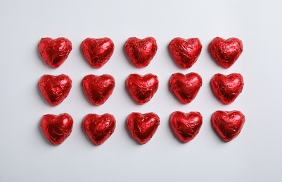 Heart shaped chocolate candies on white background, flat lay. Valentine's day treat