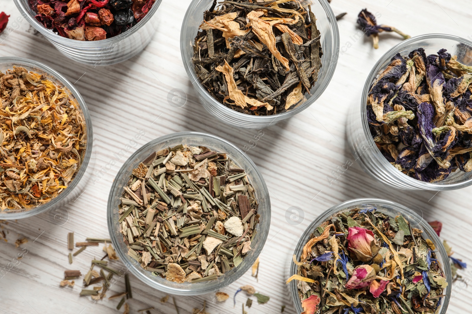 Photo of Flat lay composition with different dry teas on white wooden table