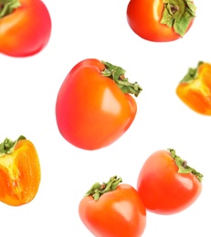 Image of Falling delicious ripe persimmons on white background 