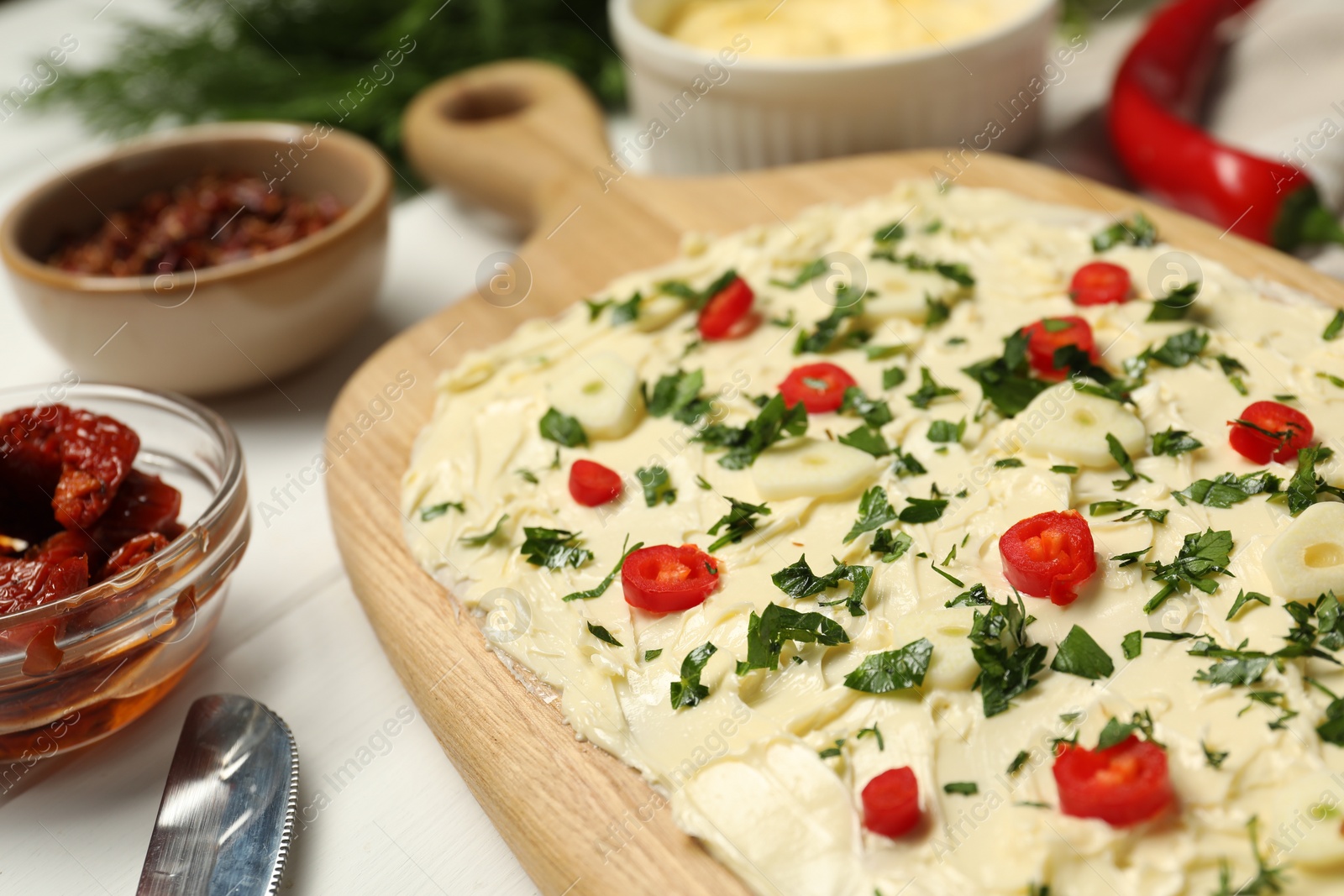 Photo of Fresh natural butter board with pepper and parsley on white table, closeup