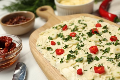 Photo of Fresh natural butter board with pepper and parsley on white table, closeup