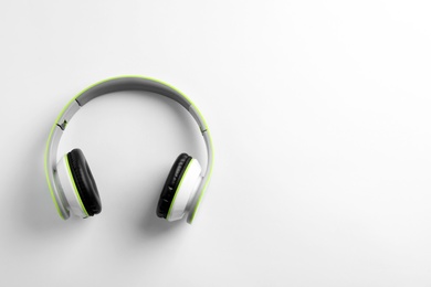 Photo of Stylish modern headphones with earmuffs on white background, top view. Space for text