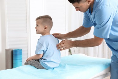 Orthopedist examining child's back in clinic. Scoliosis treatment