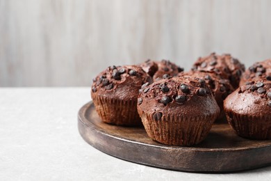 Photo of Tasty chocolate muffins on grey table, closeup. Space for text