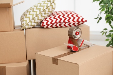 Photo of Cardboard boxes and adhesive tape, closeup. Moving day