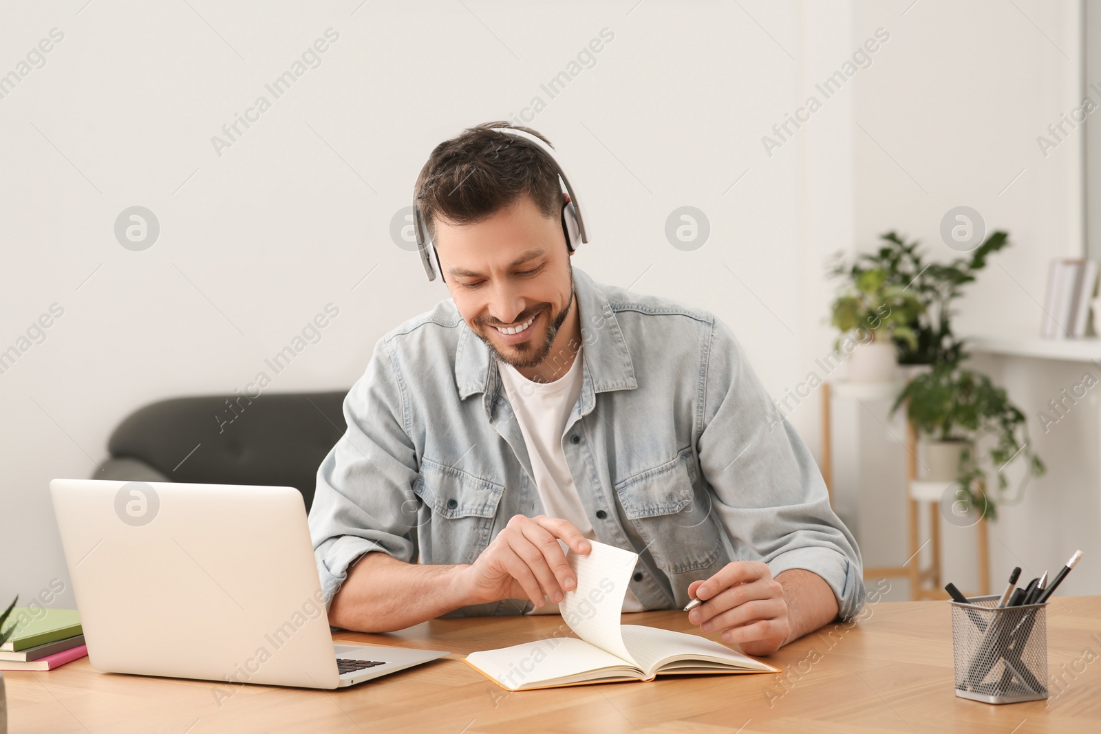 Photo of Man in headphones studying at home. Online translation course