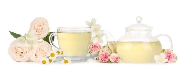 Photo of Aromatic herbal tea in glass cup, teapot and flowers isolated on white