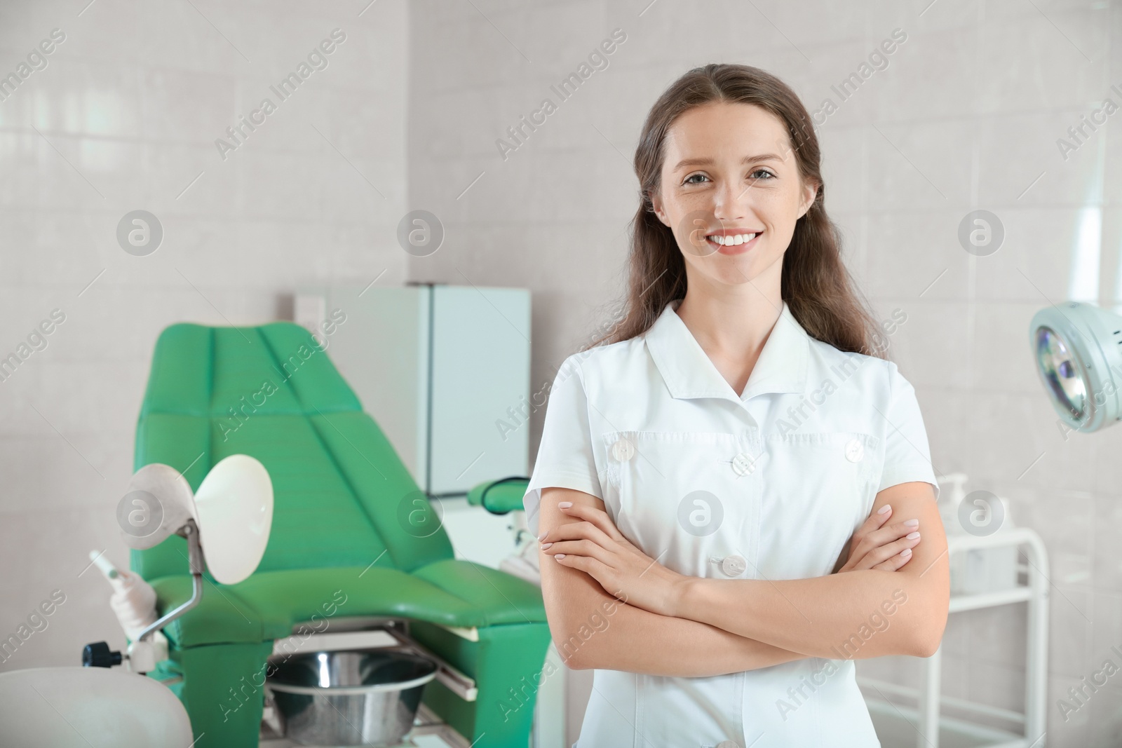 Photo of Portrait of smiling young gynecologist at workplace in clinic. Space for text