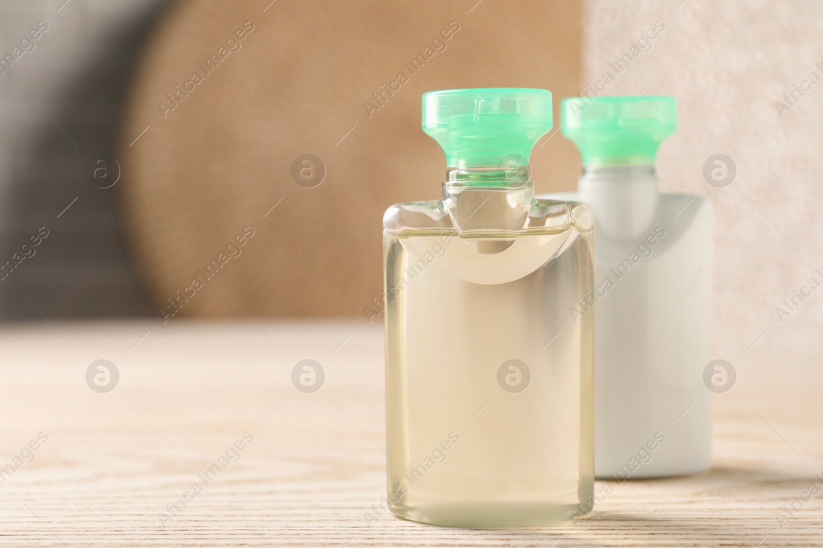 Photo of Mini bottles of cosmetic products on white wooden table, space for text