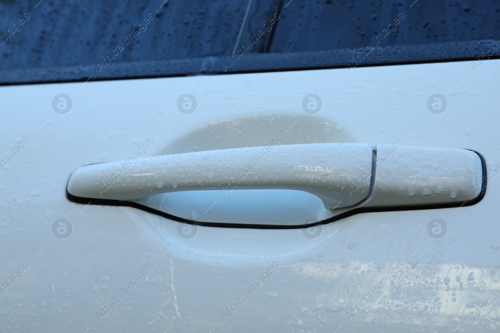 Photo of Closeup view of car door handle with water drops