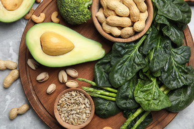 Different products rich in vitamin E on grey marble table, flat lay