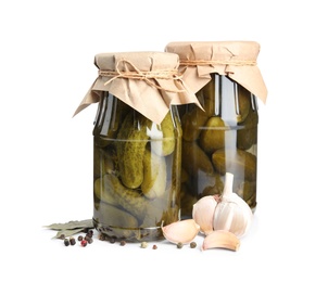 Photo of Jars with pickled cucumbers on white background