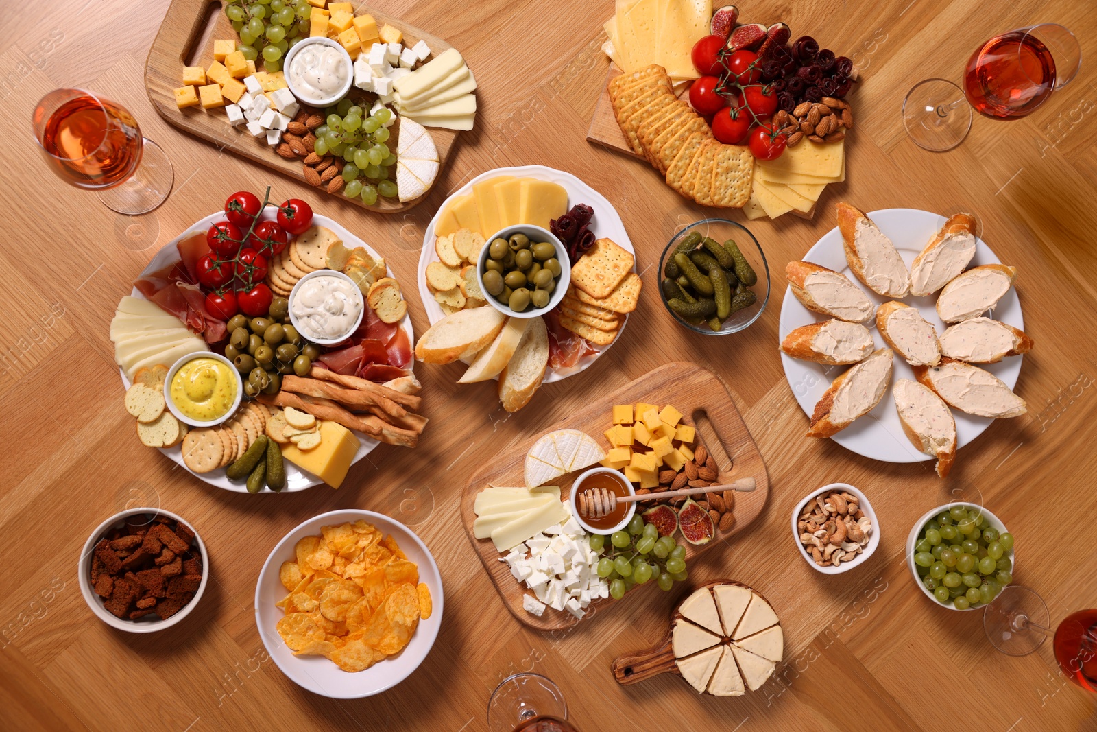 Photo of Assorted appetizers served on wooden table, flat lay