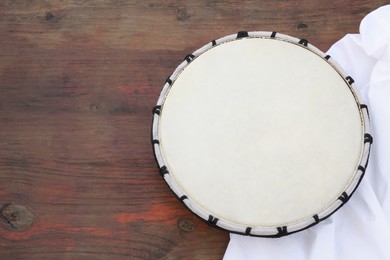 Photo of Modern drum on wooden table, top view. Space for text