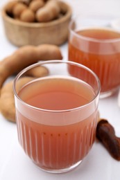 Photo of Freshly made tamarind juice on white table, closeup