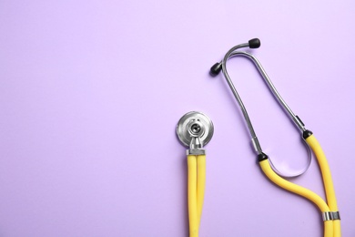 Photo of Stethoscope with space for text on color background, top view. Medical tool