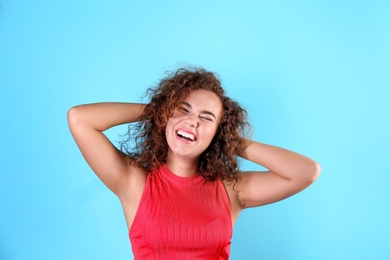 Photo of Portrait of young laughing African-American woman on color background