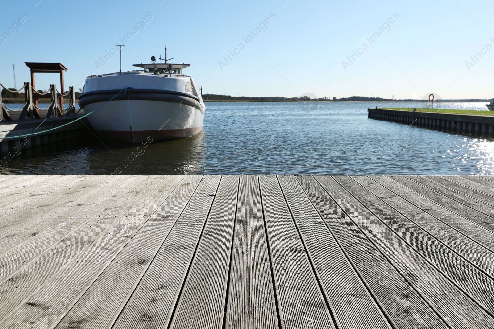 Photo of Beautiful view of wooden terrace and boat near river on sunny day