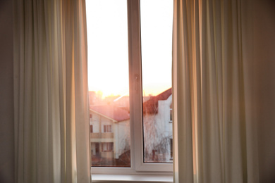 Photo of Window with beautiful beige curtains, closeup view
