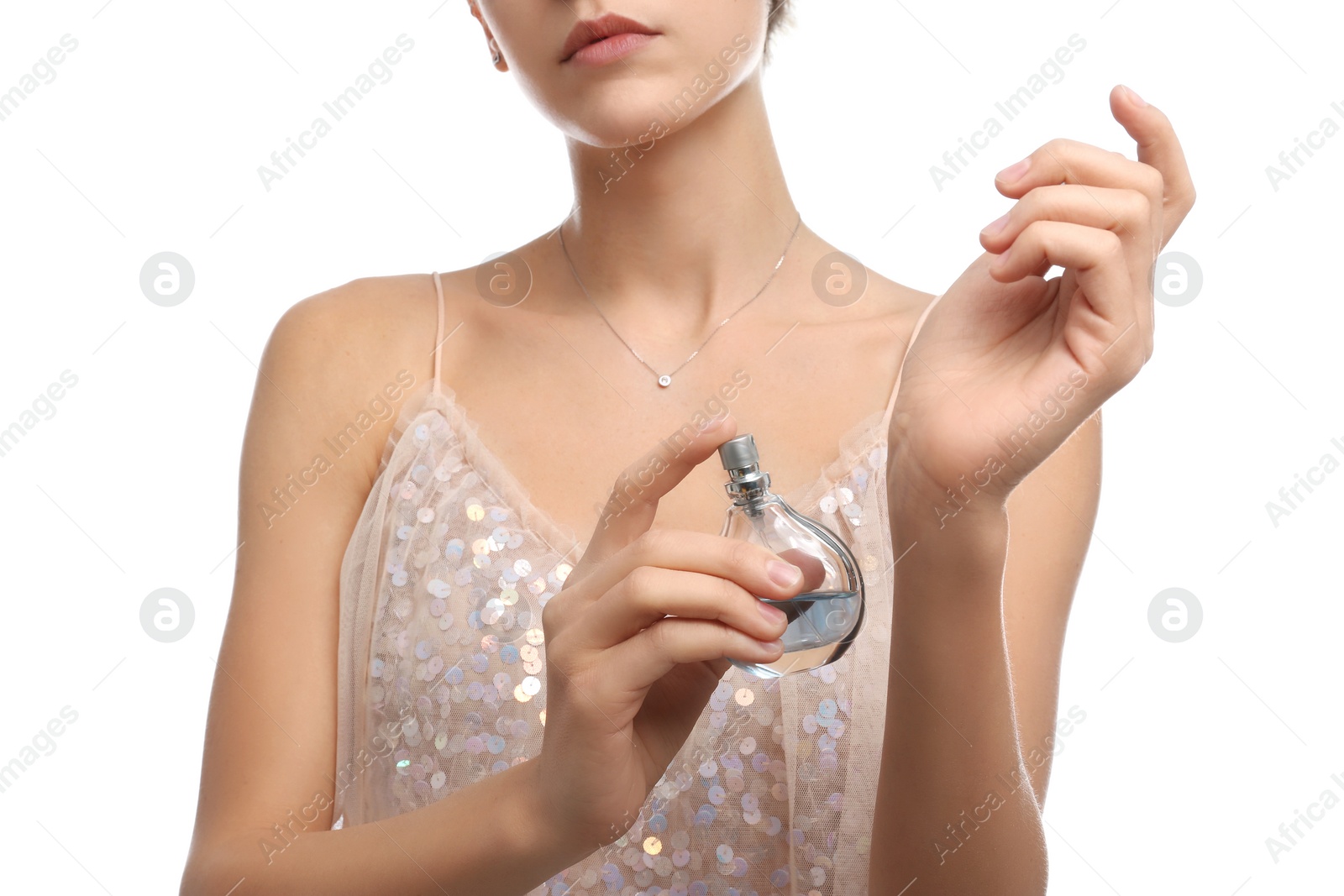 Photo of Young woman spraying perfume onto skin against white background, closeup