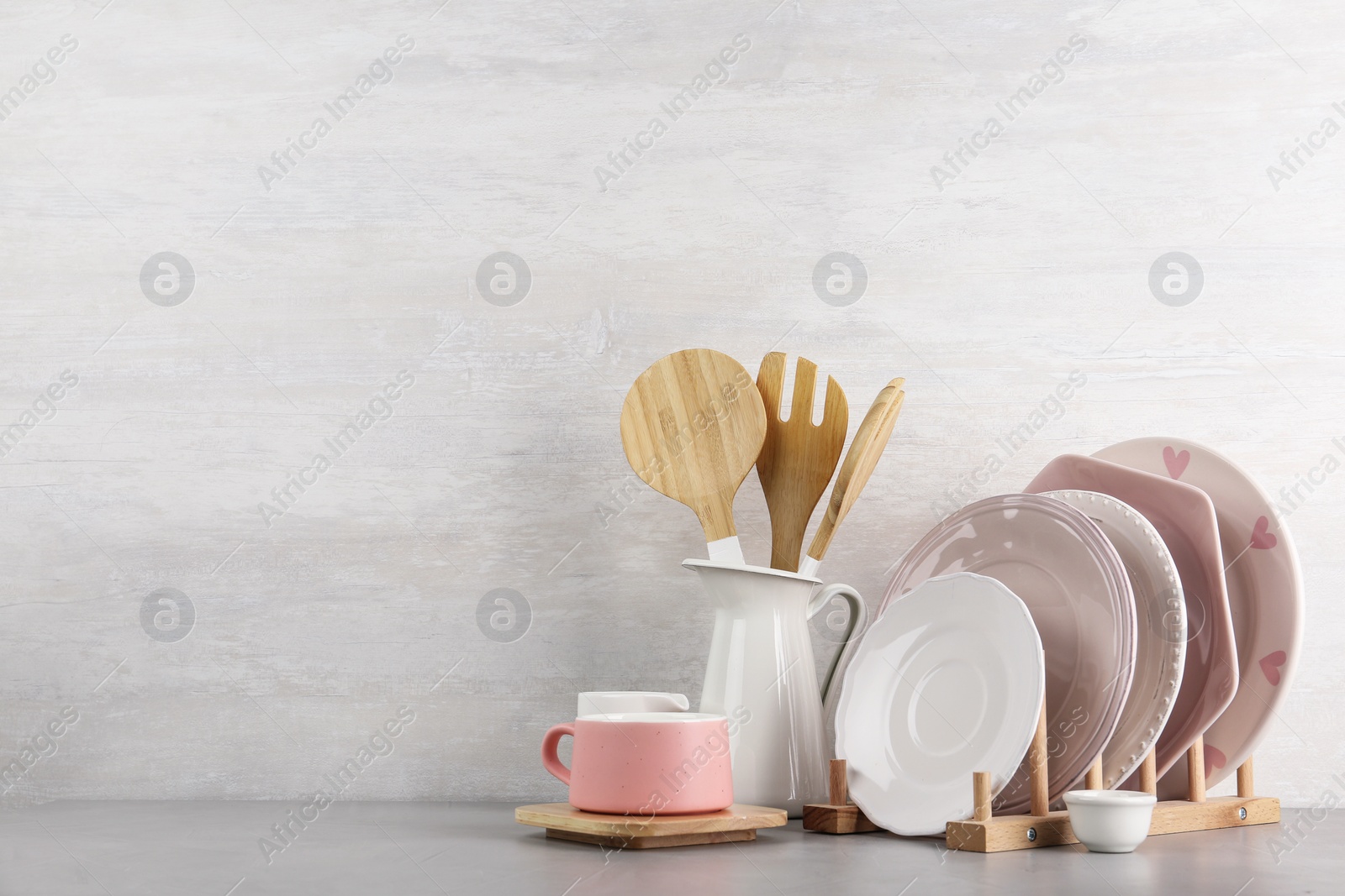 Photo of Set of kitchenware on table near light wall, space for text. Modern interior design