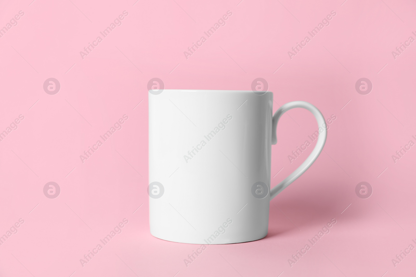 One white ceramic mug on pink background Photo of One white ceramic mug on pink background