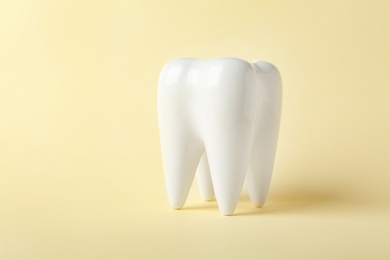 Photo of Ceramic model of tooth on color background. Space for text