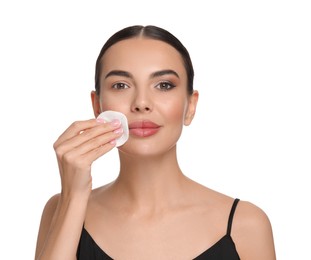 Photo of Beautiful woman removing makeup with cotton pad on white background