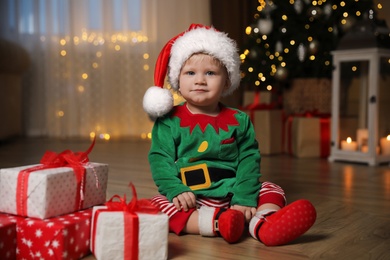 Photo of Baby in cute Christmas outfit with gifts at home