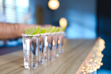 Mexican Tequila shots with salt and lime slices on bar counter