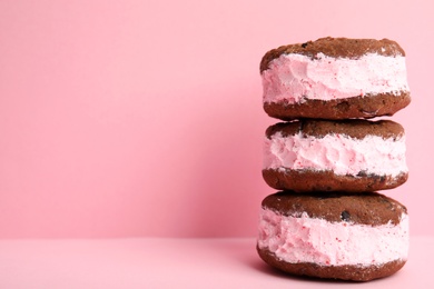 Photo of Sweet delicious ice cream cookie sandwiches on color background, space for text