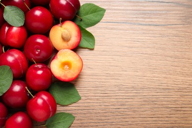 Photo of Fresh ripe cherry plums on wooden table, flat lay. Space for text