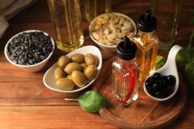 Photo of Different cooking oils and ingredients on wooden table