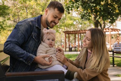 Photo of Happy parents with their baby in park on sunny day