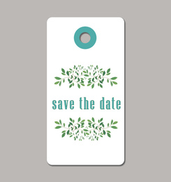 Wedding Save The Date tag with floral design on grey background, top view